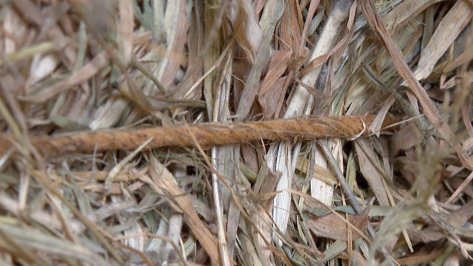 Close up of a hay bale, which is wrapped with brown twine going around it