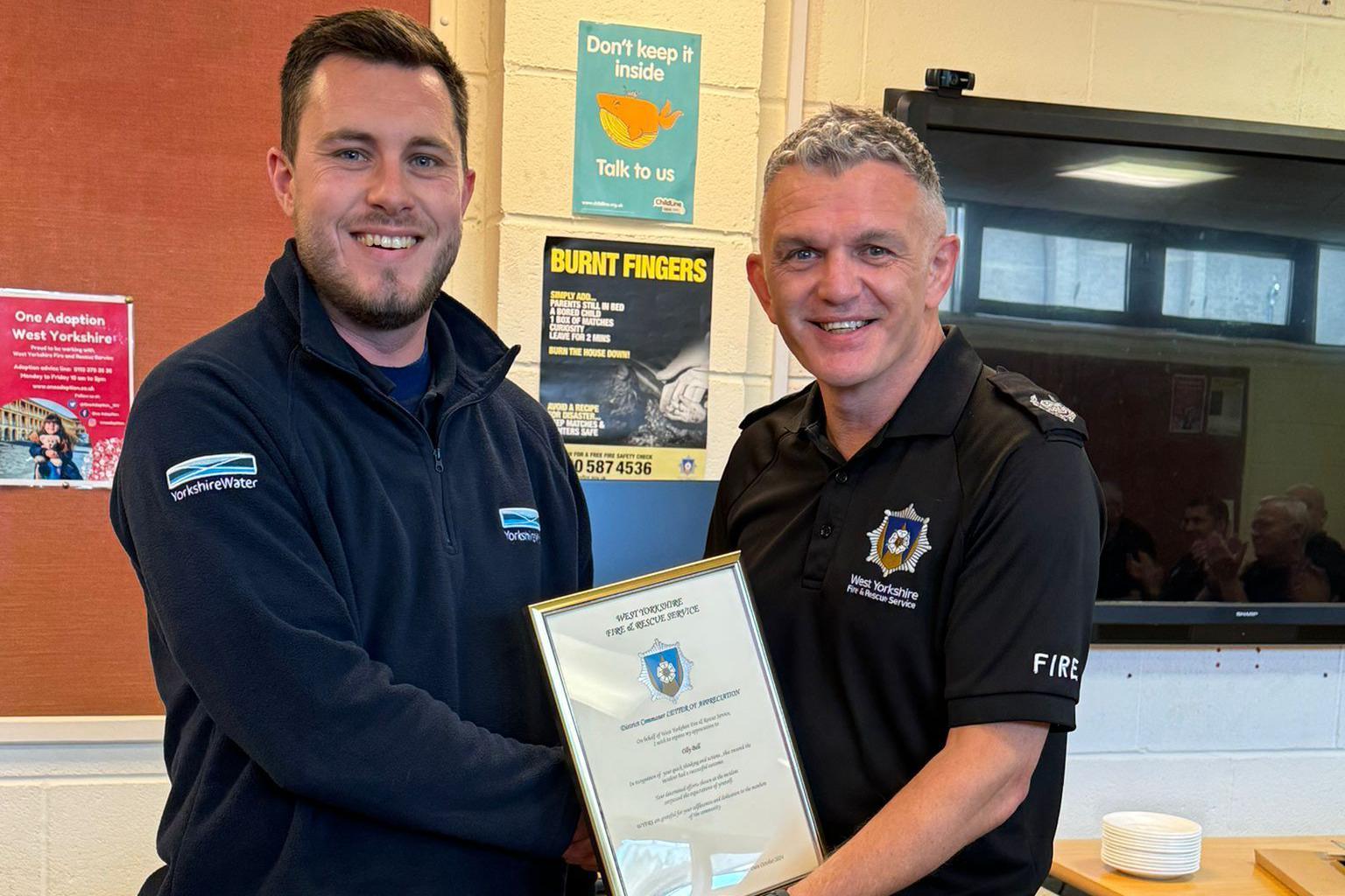 Olly Bell receiving his award from district commander Dale Gardiner