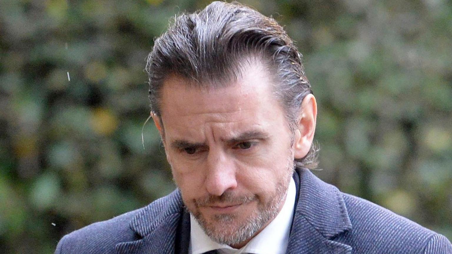 Man in shirt and tie with his head looking to the ground