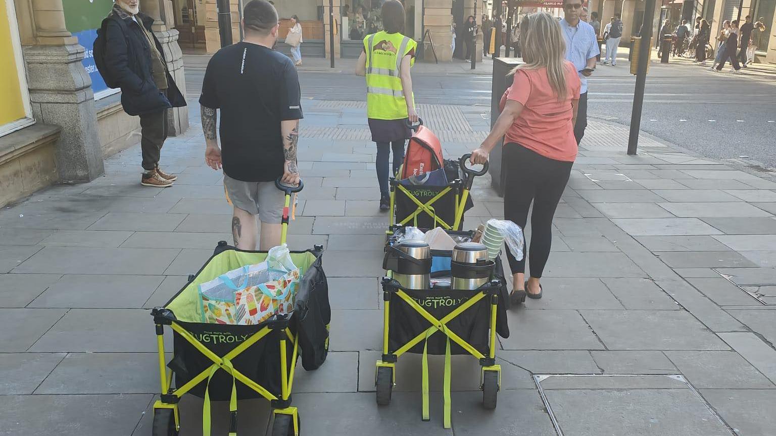 Volunteers at the charity can be seen wheeling trolleys filled with items to support homeless people, including hot drinks.
