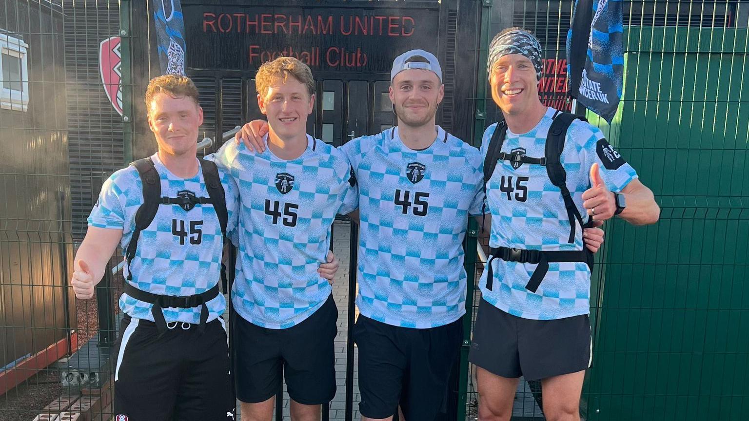 Four young men in football shirts outside Rotherham United's ground