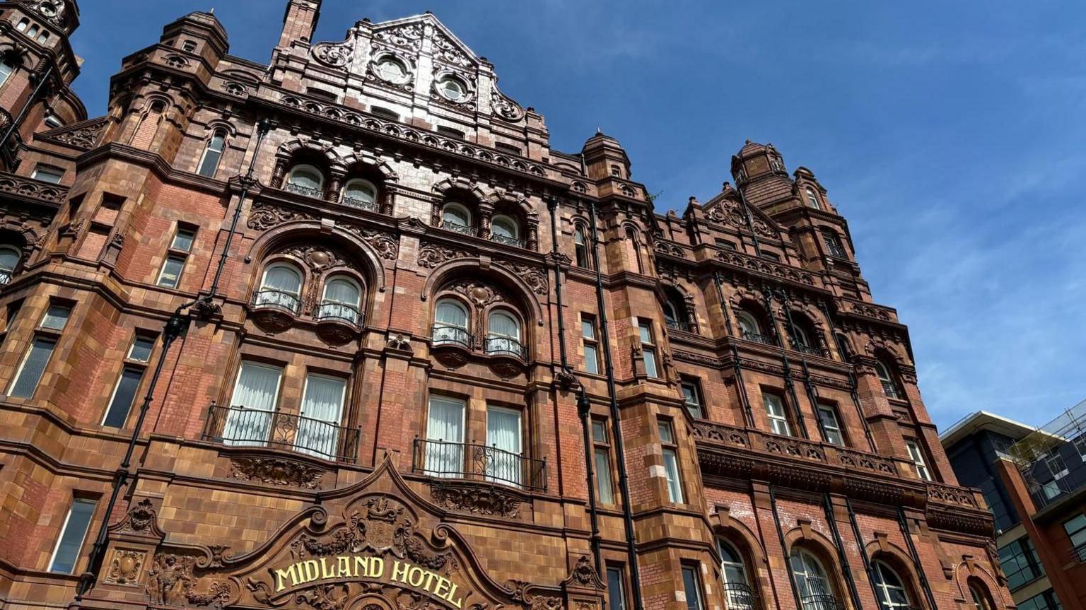 The Midland Hotel in Manchester with blue skies and red brick building