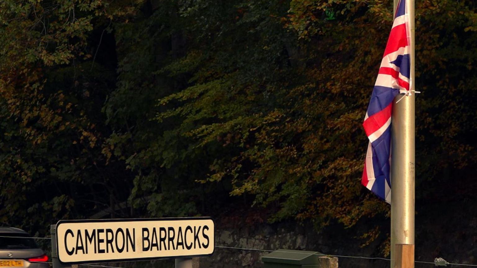 A Union flag on a lamppost next to a sign that reads: "Cameron Barracks".