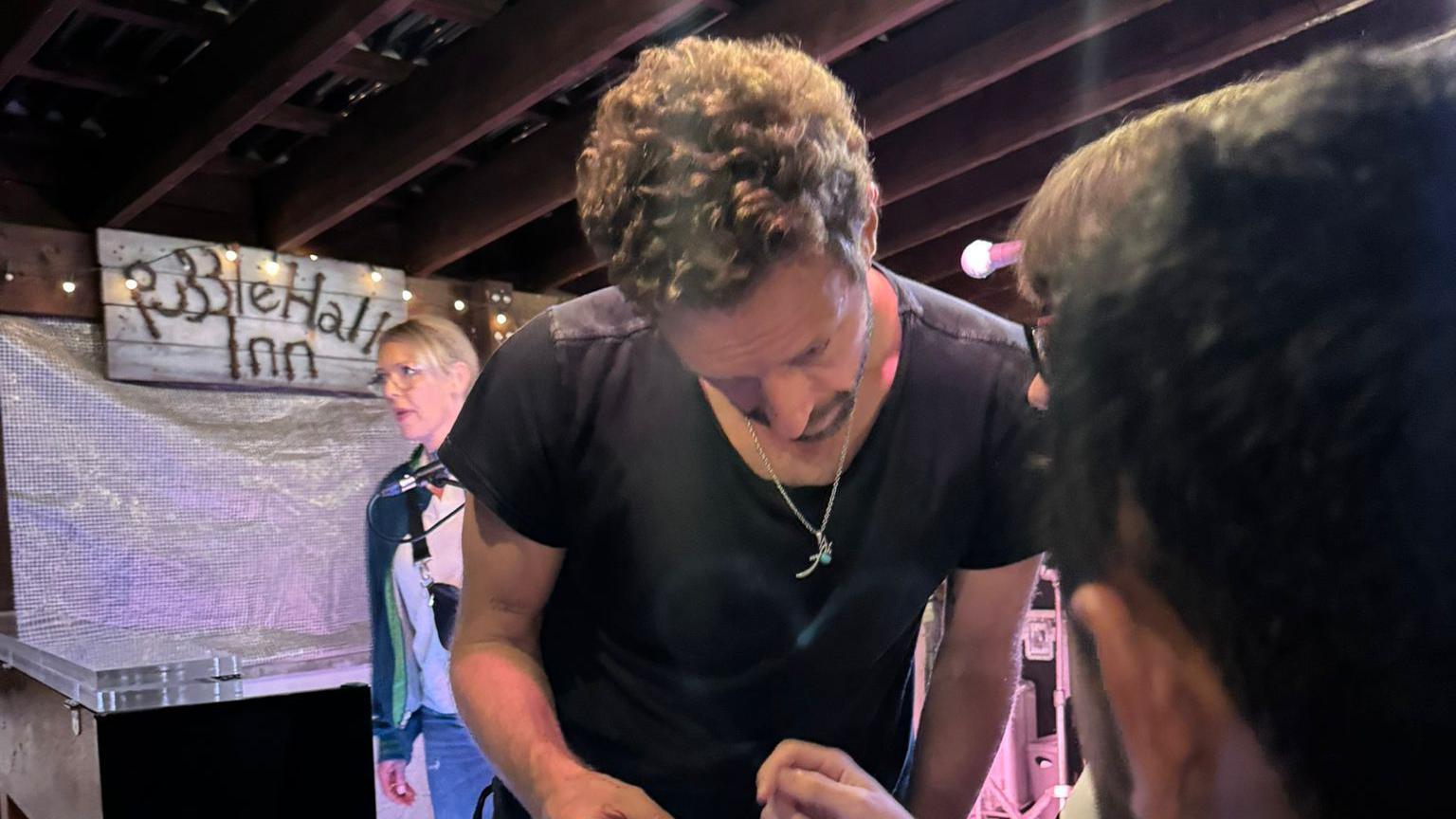 Chris Martin smiling and talking to a fan at the  Puzzle Hall Inn in Calderdale