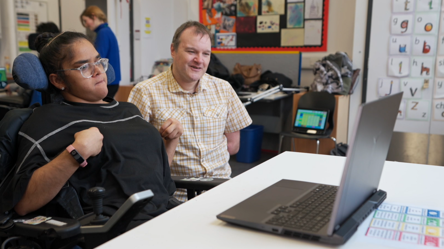 Safiya pictured using MotionInput on a laptop while Paul watches