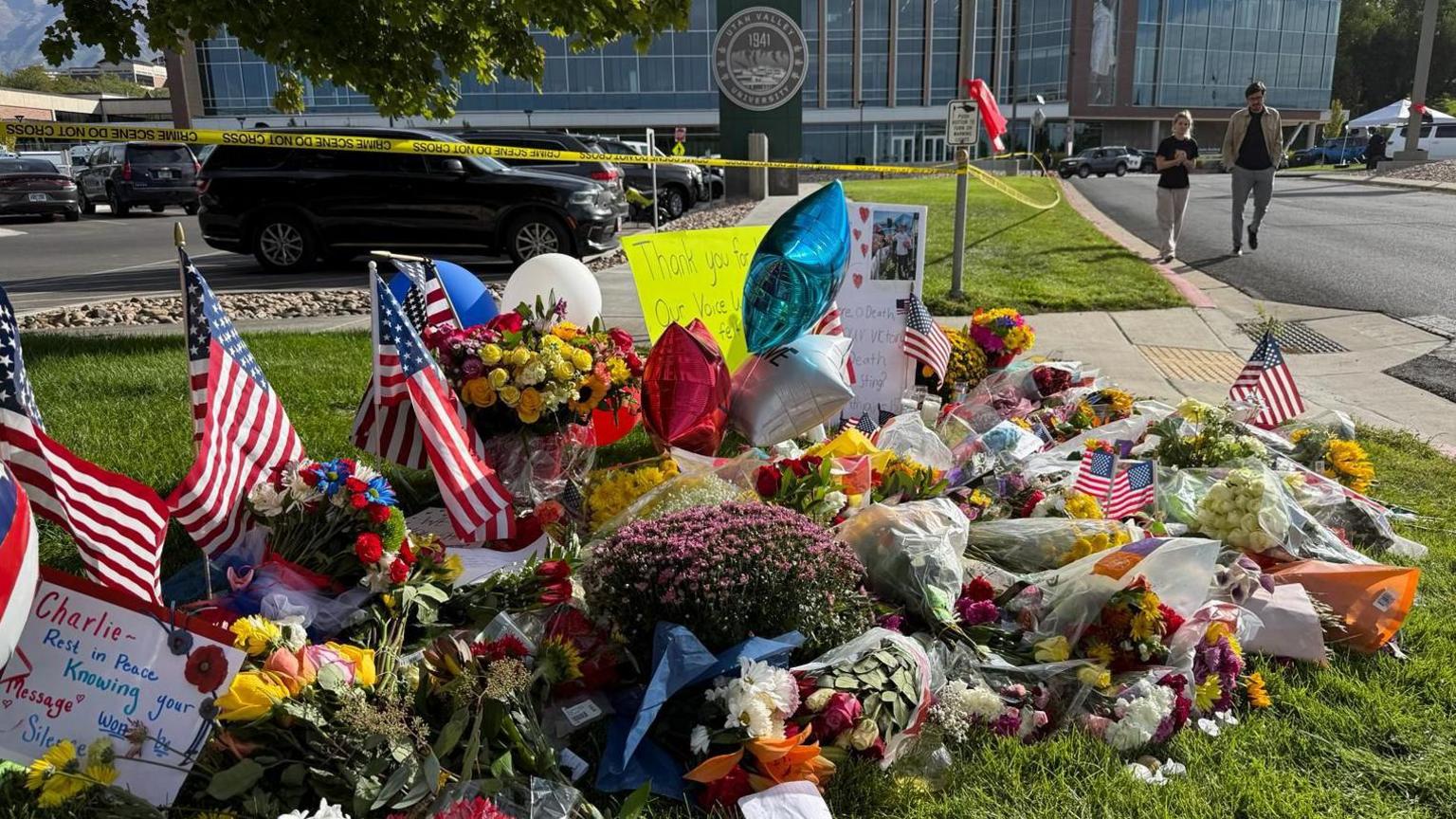 A memorial is on display with flowers and signs commemorating Charlie Kirk at the campus.