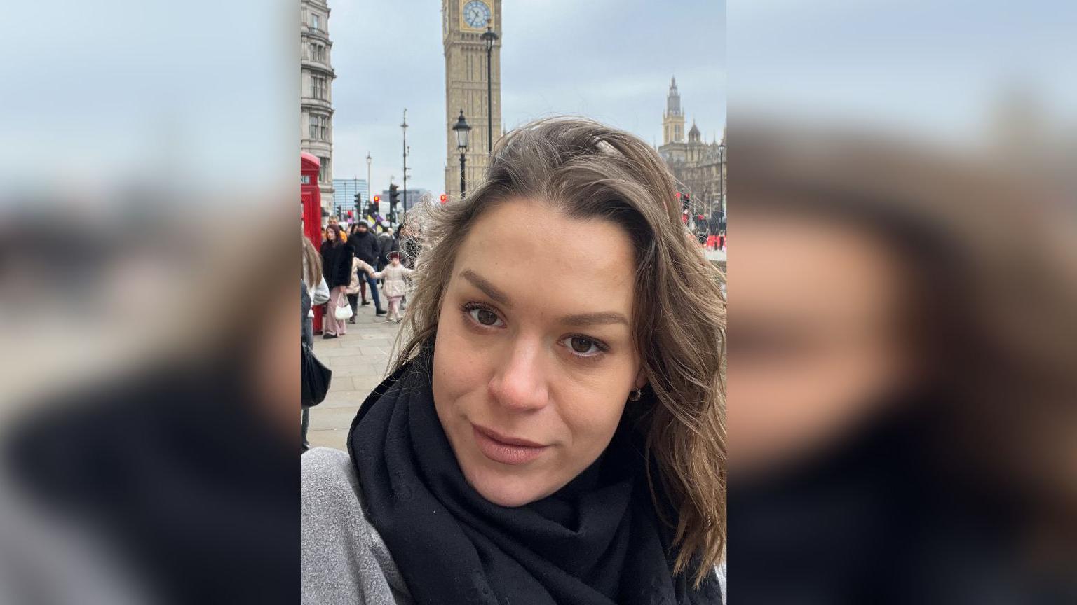 A woman with the Palace of Westminster behind her. 