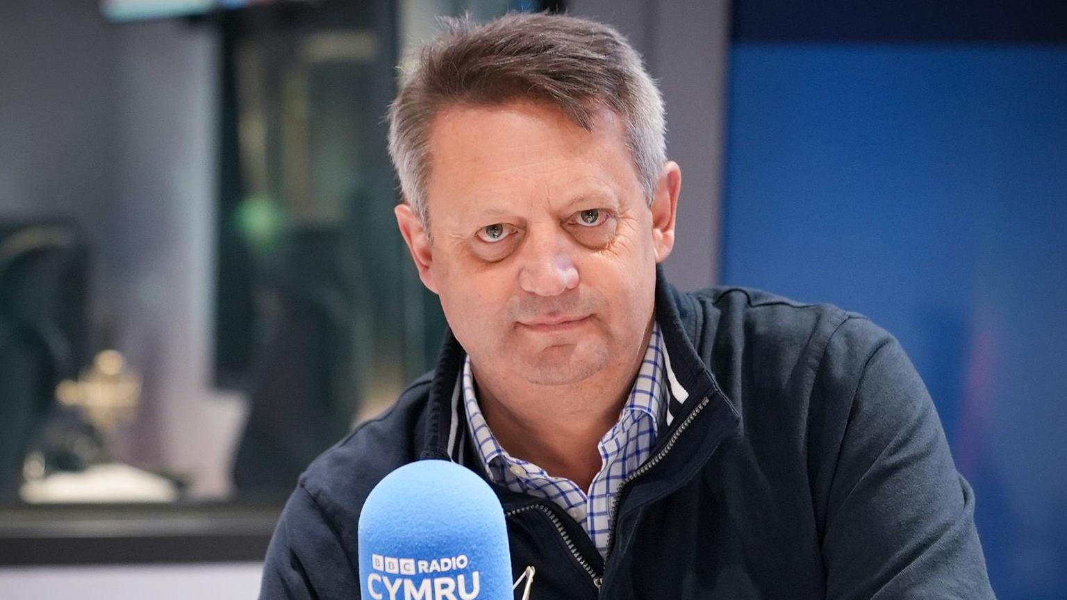 Alun Davies yn eistedd yn stiwdio Radio Cymru