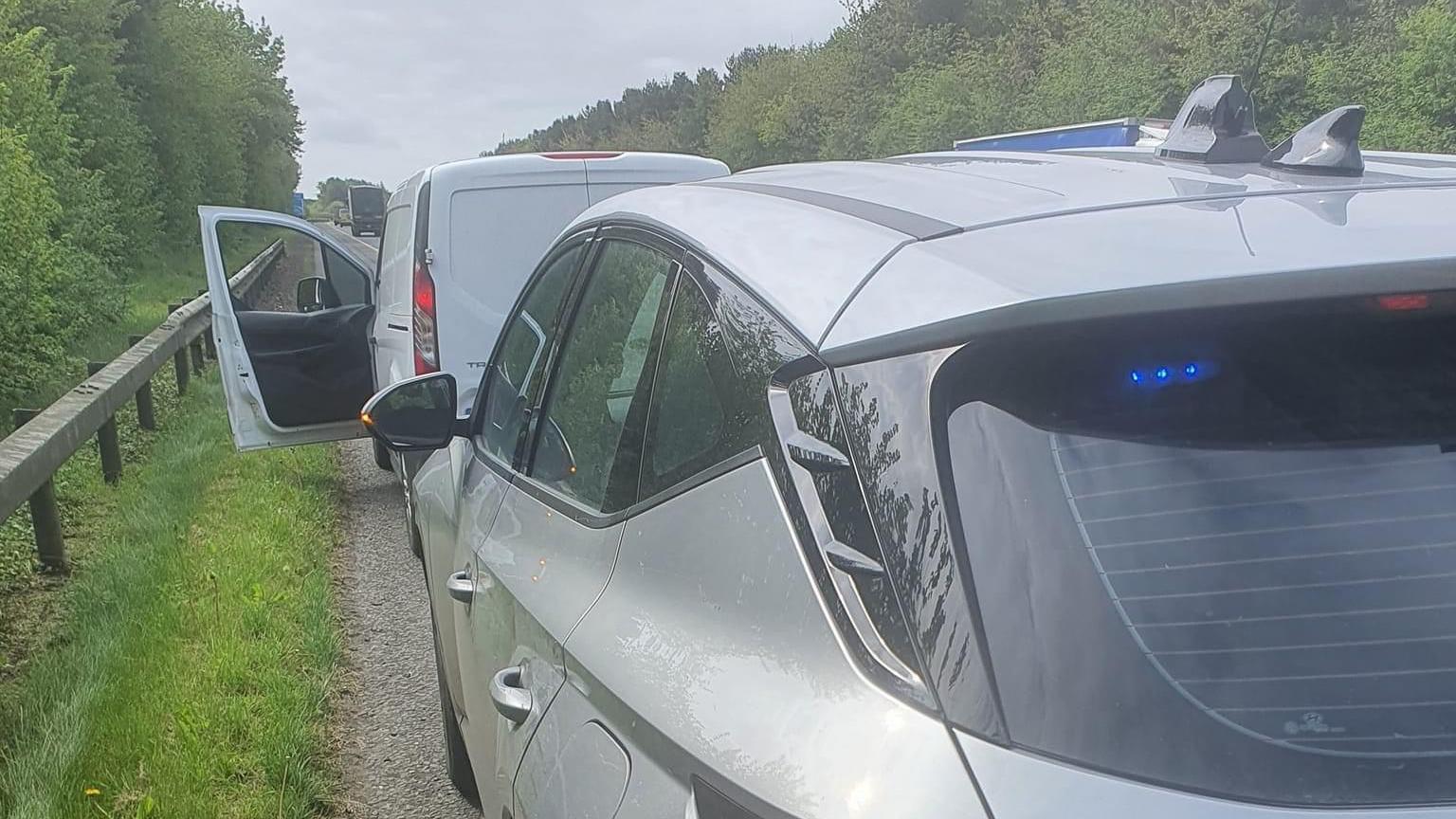 White van stopped by a silver Garda car by the side of the road