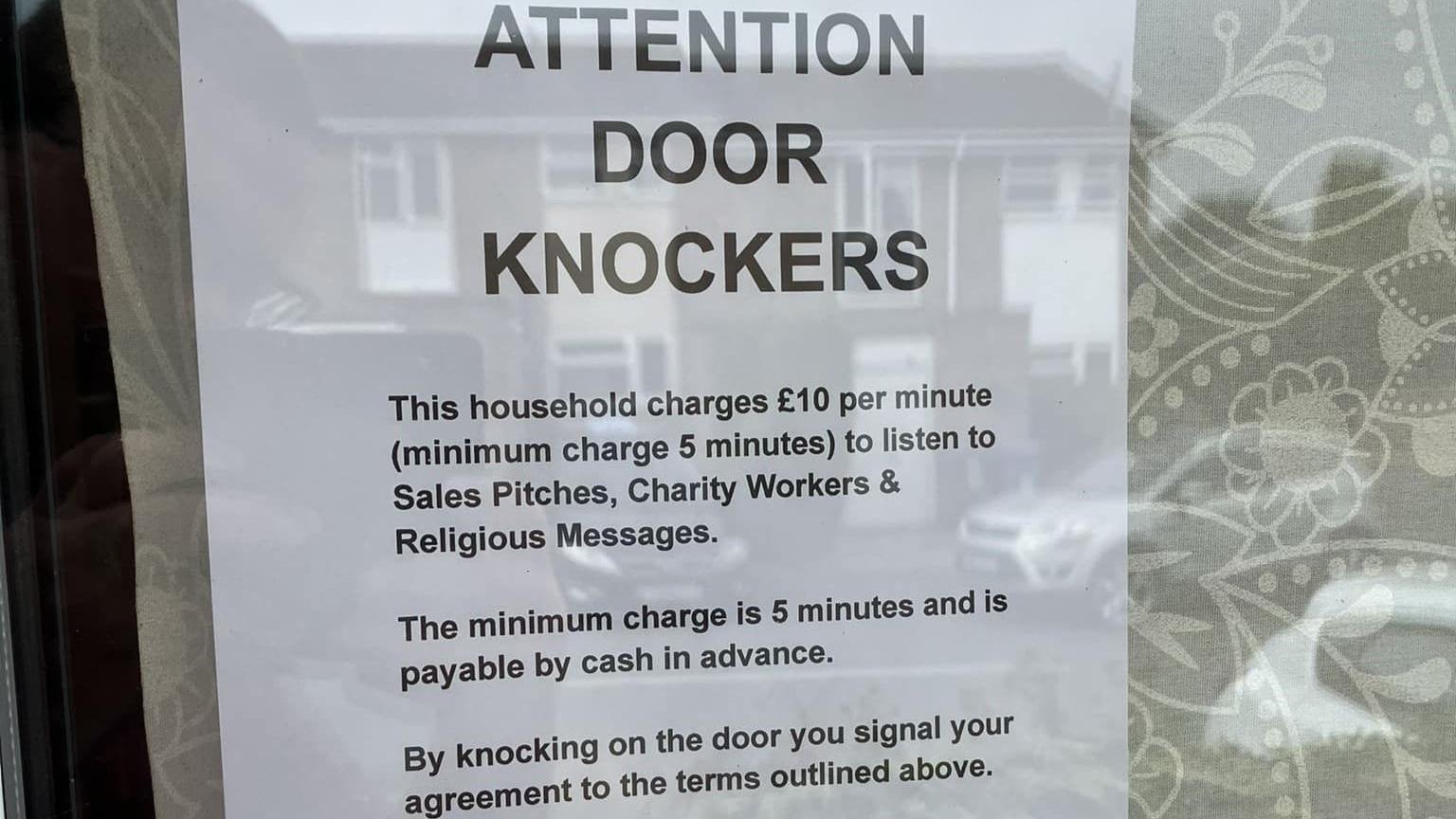 A poster in a window that says "ATTENTION DOOD KNOCKERS" with more writing underneath explaining how much cold-callers will be charged.