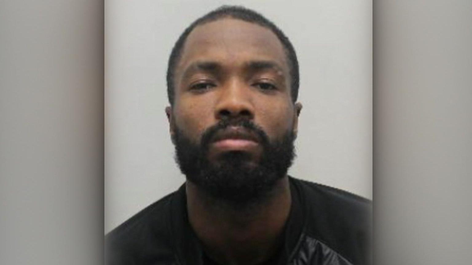 Custody photo of Javon Riley, who has a beard and moustache.