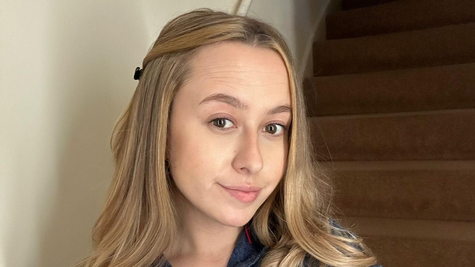 Një selfie e Cait me flokë bjonde me shkallë druri pas saj