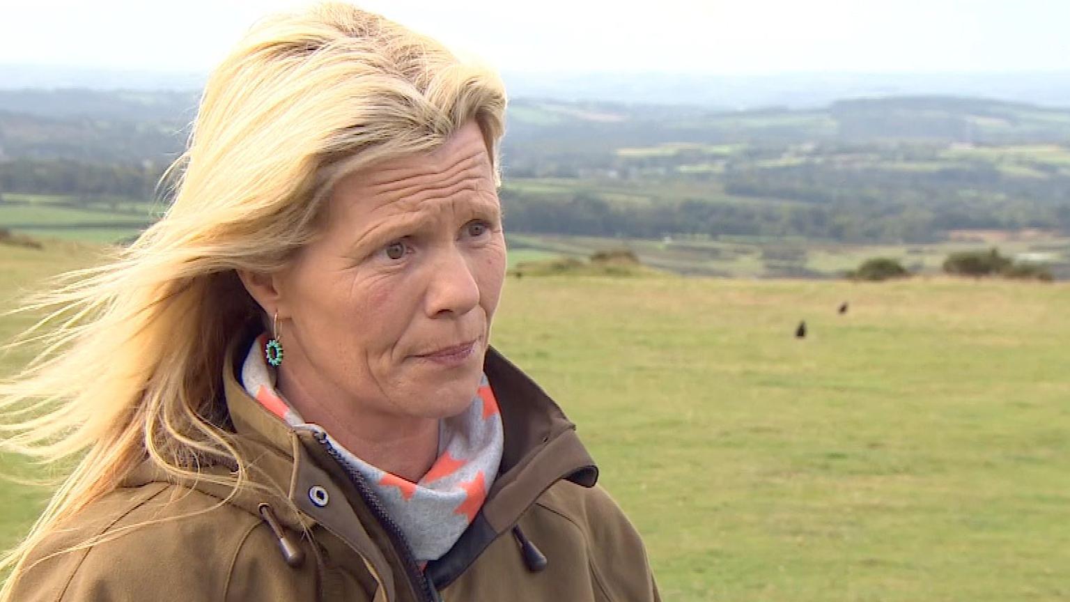 A lady with blonde hair with Dartmoor in the background