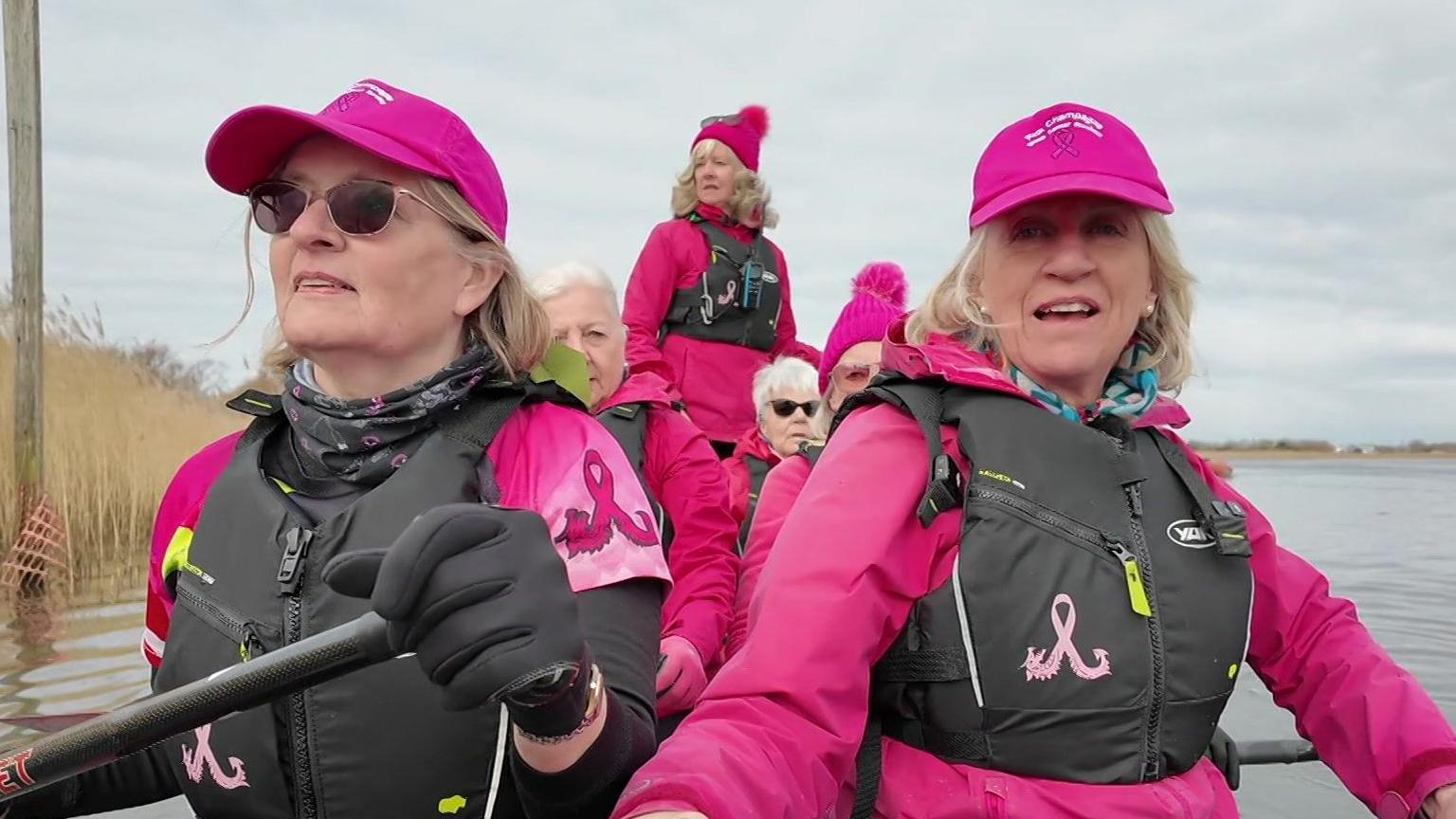 Sally Taylor and other women all wearing pink and rowing a dragon boat