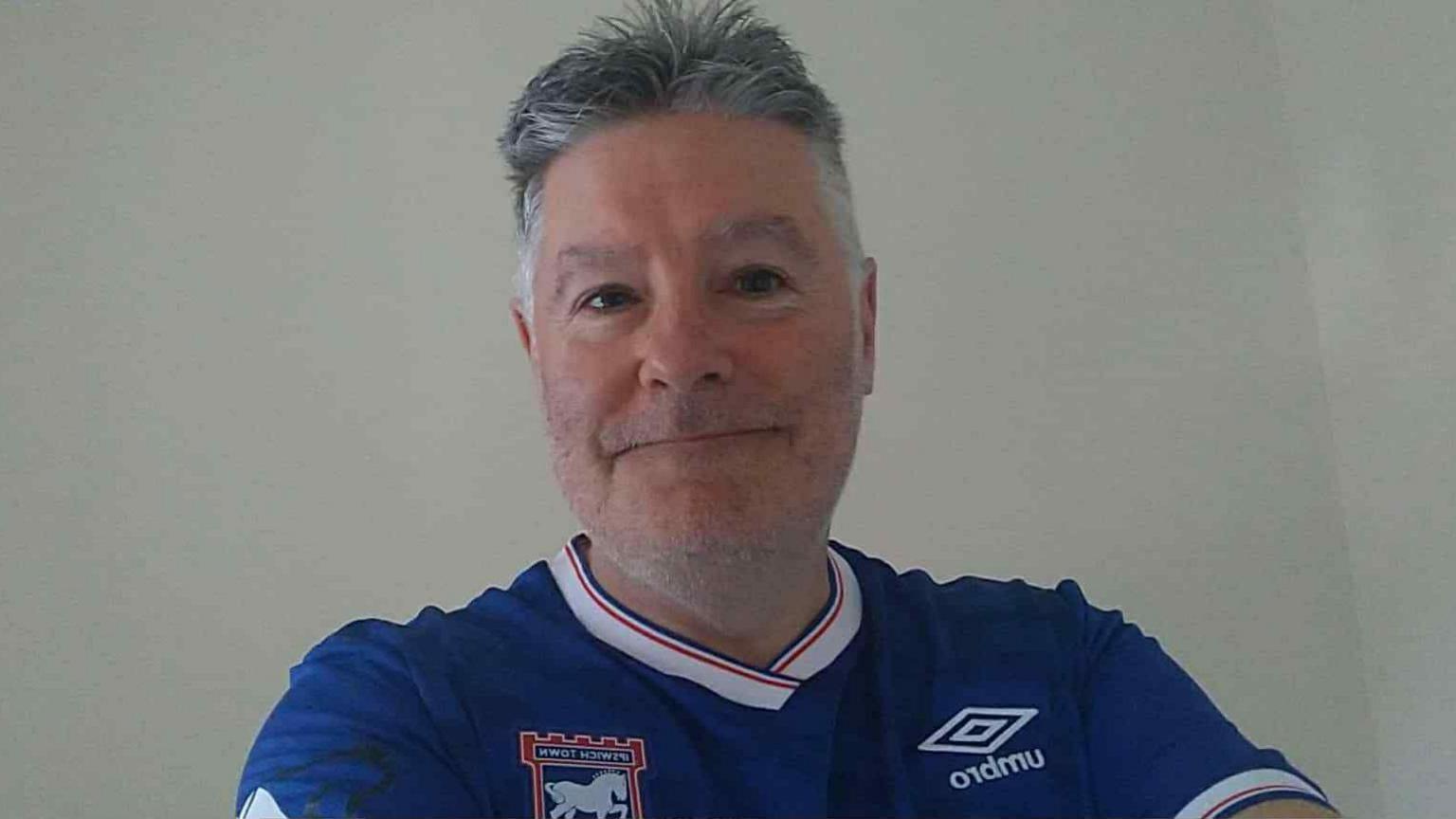 A selfie style image of Tim Kenny. He is wearing a blue Ipswich Town top and looking into the camera.