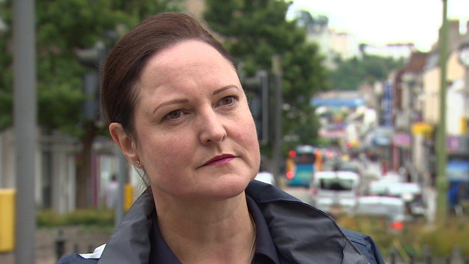 Alison Hernandez looking serious with busy street in background