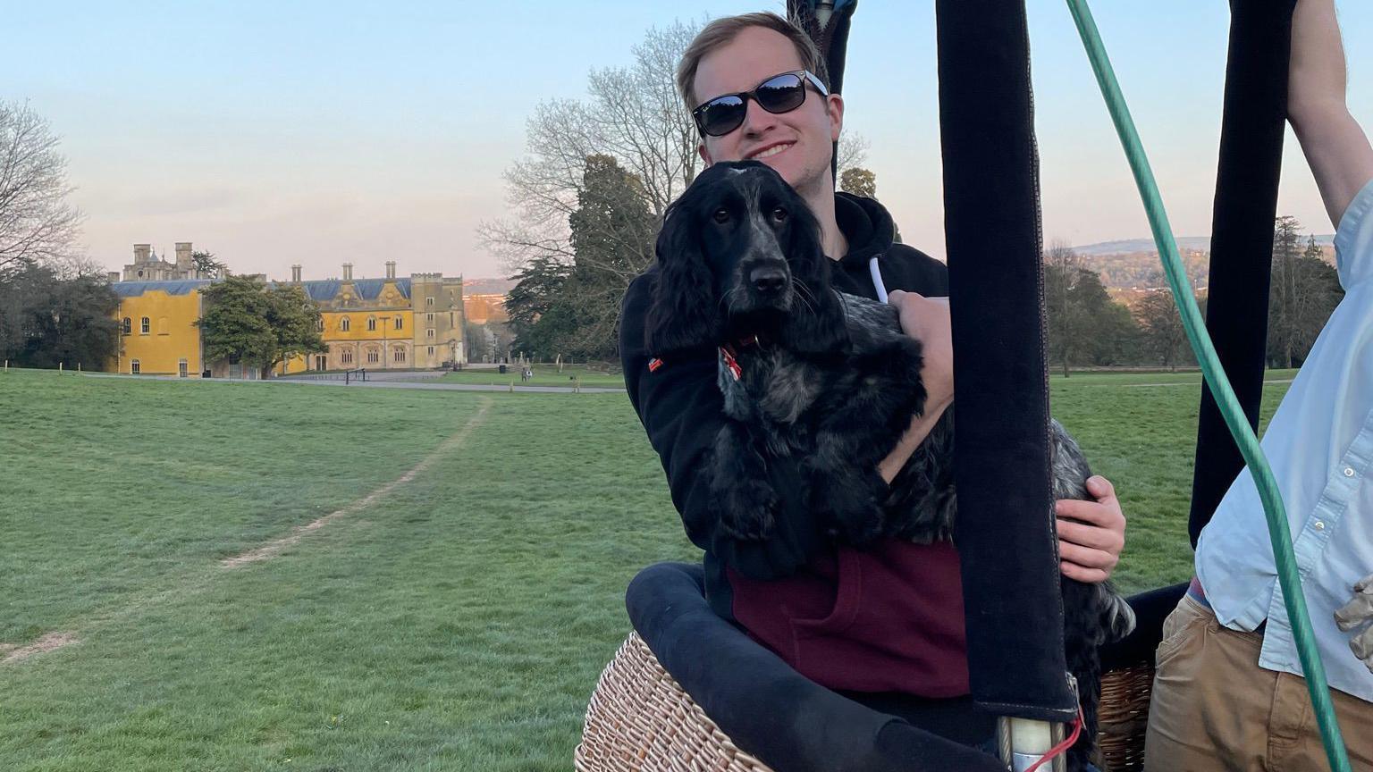 Max in a hot air balloon holding a dog