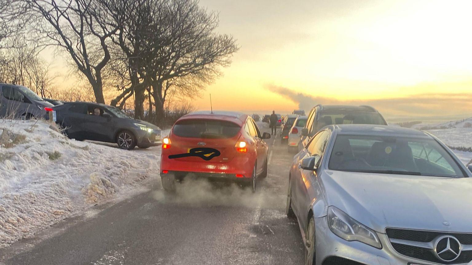 Cars everywhere on a snowy rural road