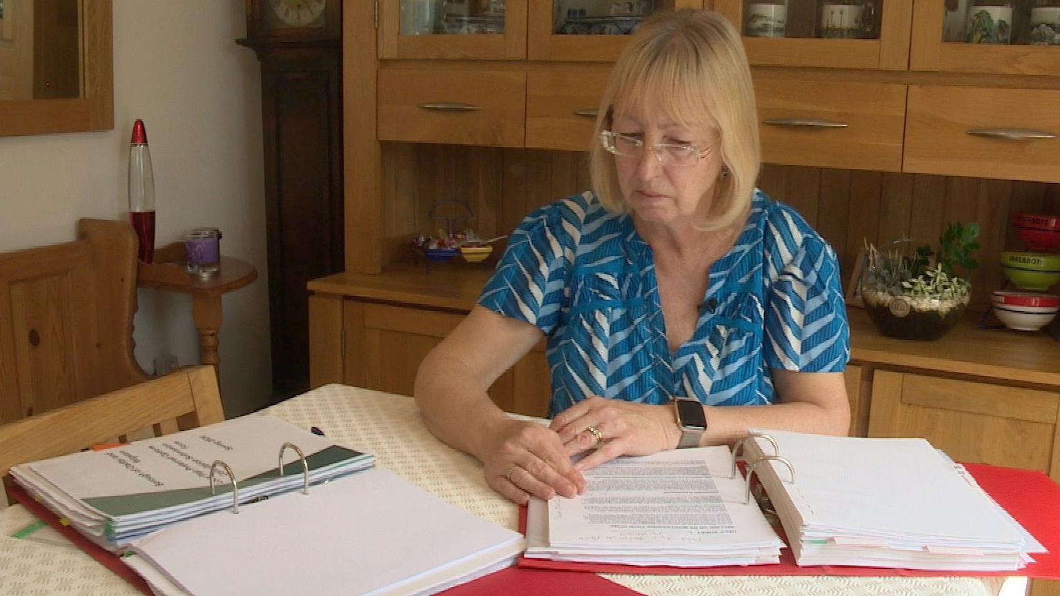 Karen sits at her dining table looking at the documents she has from FirstPort