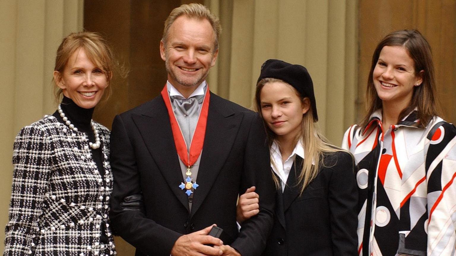 Sting's wife Trudie Styler in black and white checked jacket, Sting in dark suit with CBE around his neck and his daughter Coco in black jacked and Kate in white, red and black geometric shirt, at Buckingham Palace, which he received for services to the music industry. "I'm surprised and flattered to receive this honour," he said recently. "If my mum and dad were still here they would be made up."