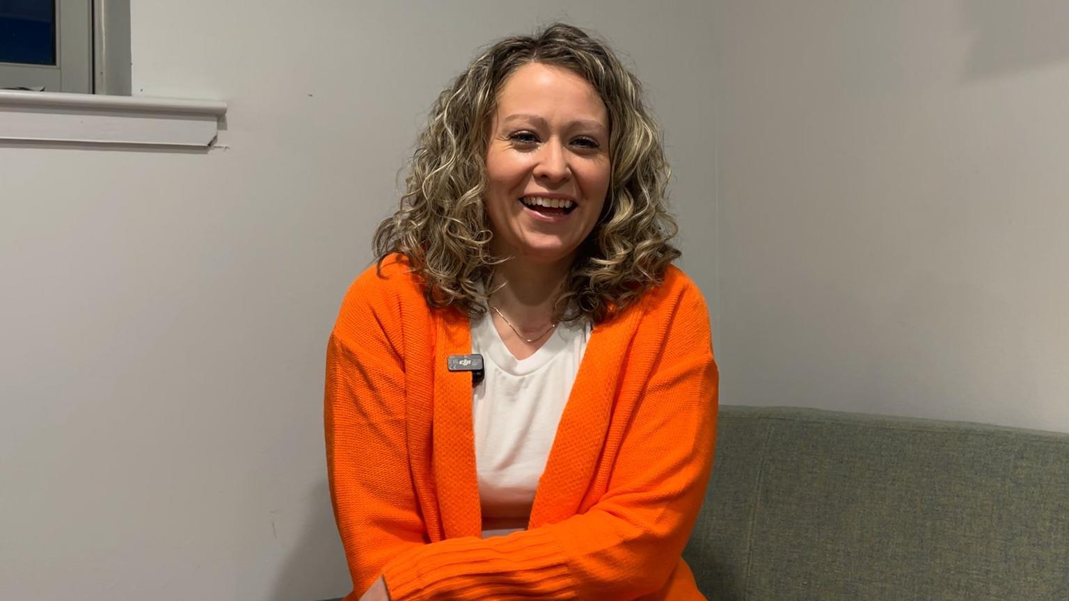 Dealbh de Chairistiona NicLeòid, a tha le Type 1 agus i na suidhe agus gàire mhòr air a h-aodann. 