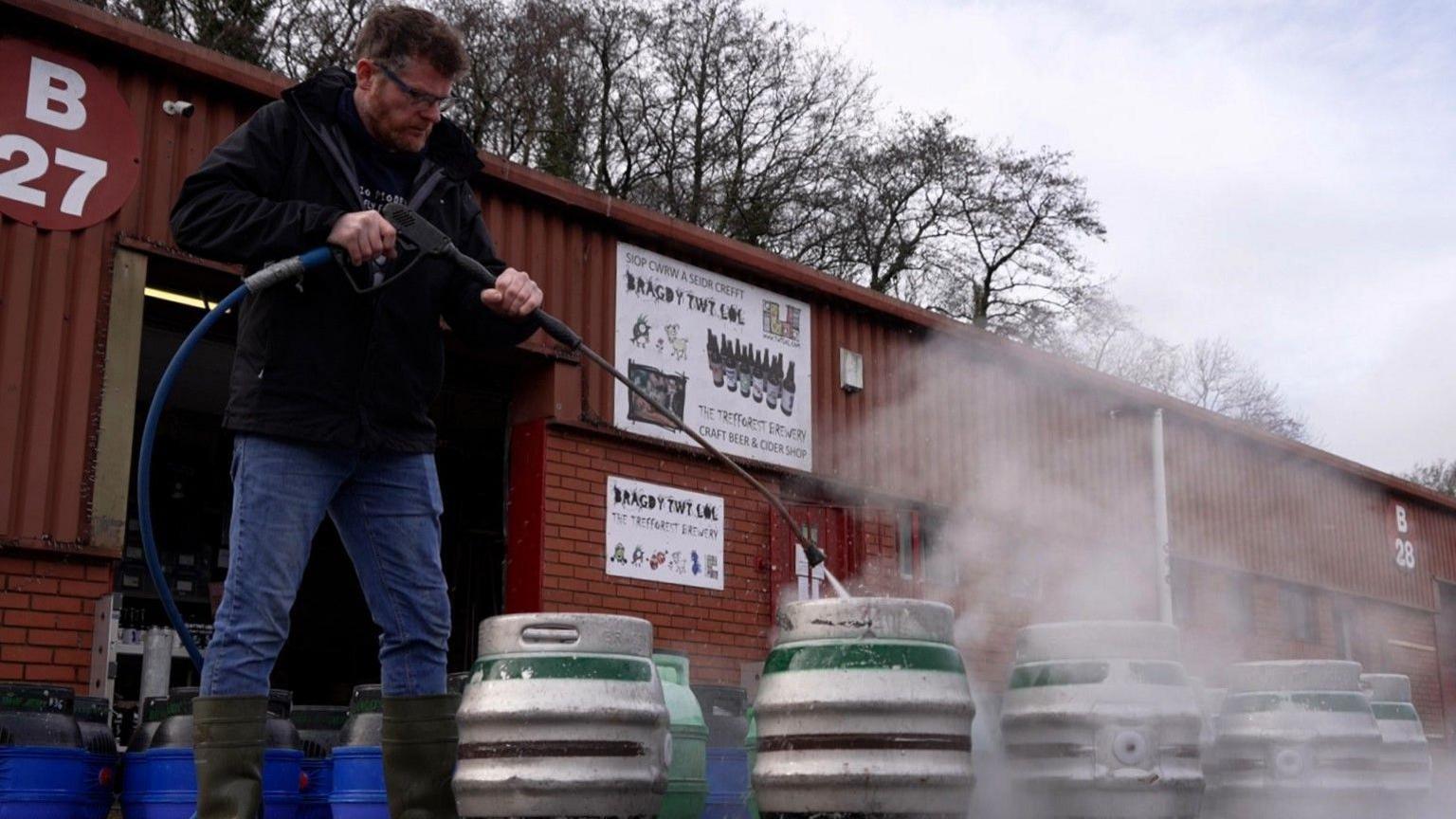 Llun Philip Thomas yn gweithio tu allan i'r bragdy