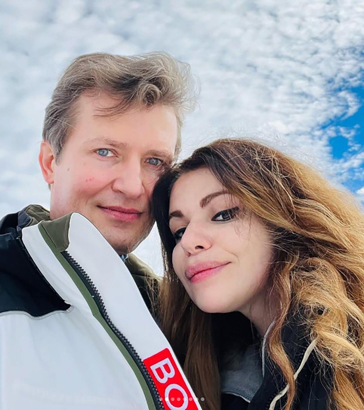 A selfie of the couple, who are looking downwards at the camera, with blue skies in the background