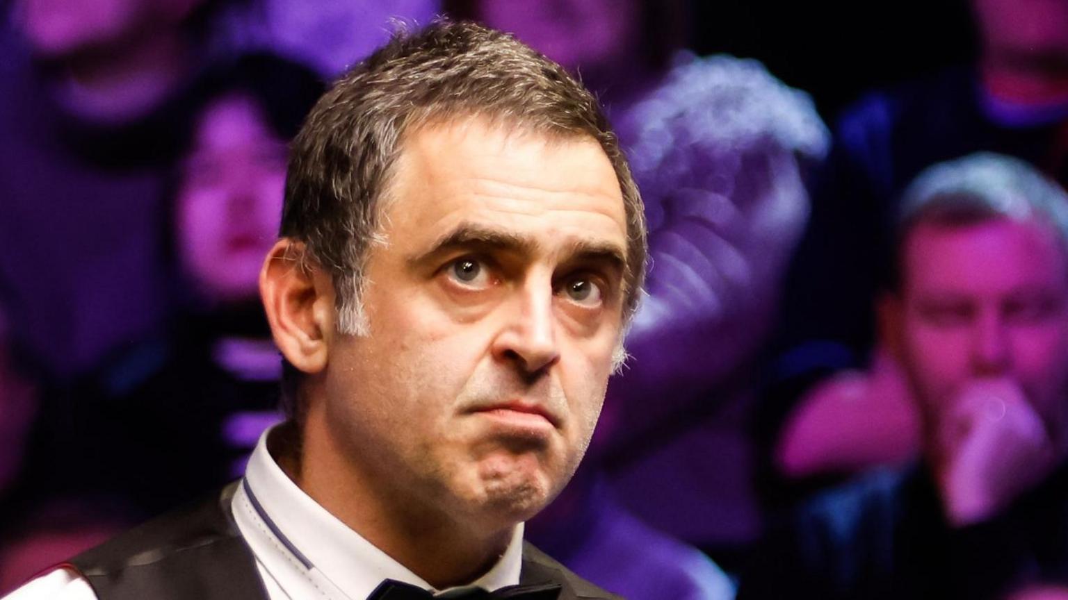 Ronnie O'Sullivan looks at a snooker table