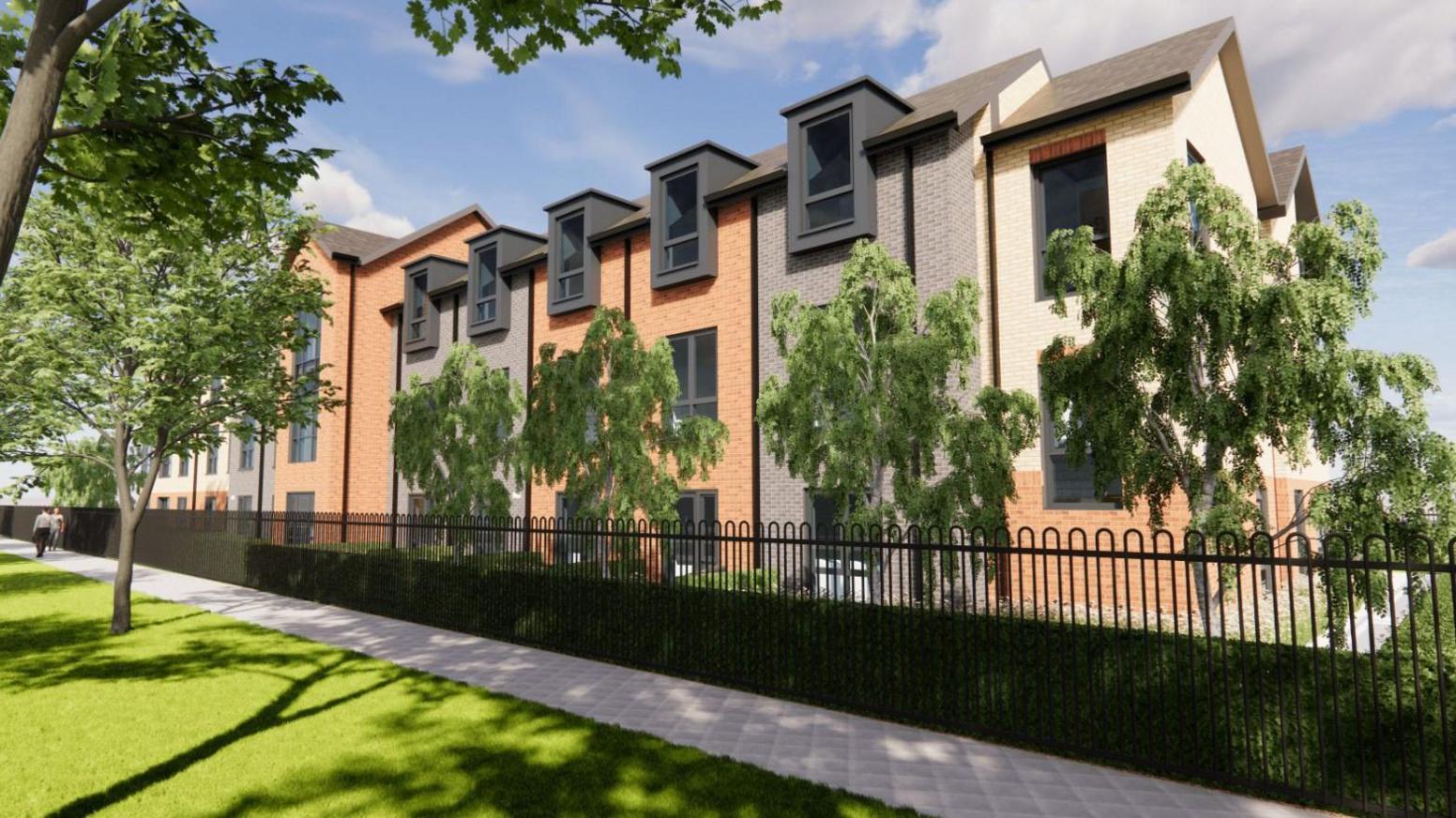 An artist's impression of the proposed care home. It shows the exterior of the three-storey building, with dark-coloured, red and yellow brick. It has dark-outlined windows on each floor. Green trees line the outside of the building, as do green bushes and black railings. There is a white path and grass outside the grounds. The sky is blue with light clouds. 
