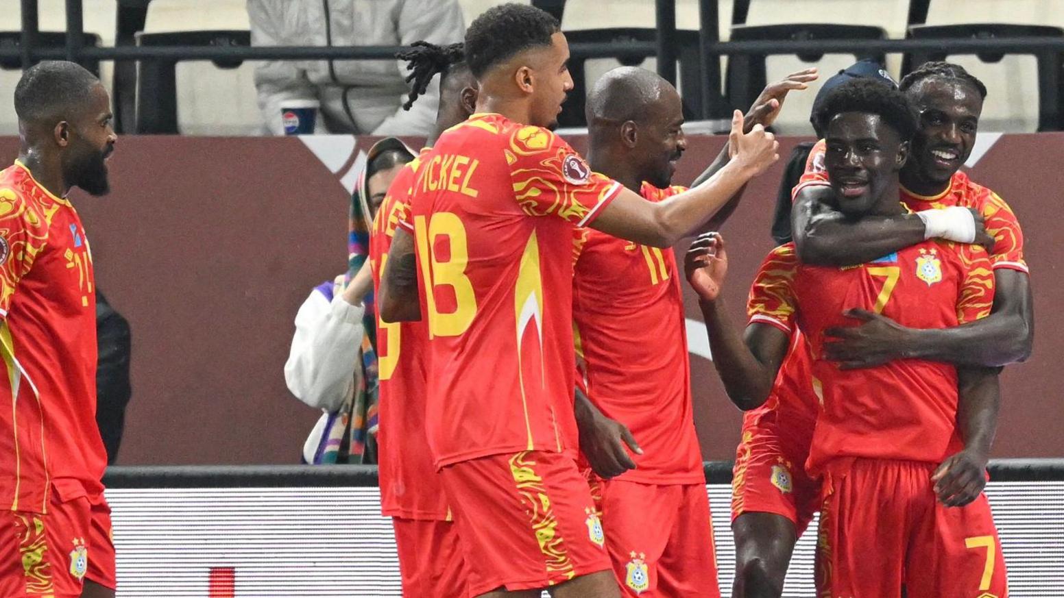 DR Congo players, dressed in an all-red kit, celebrate a goal against Botswana