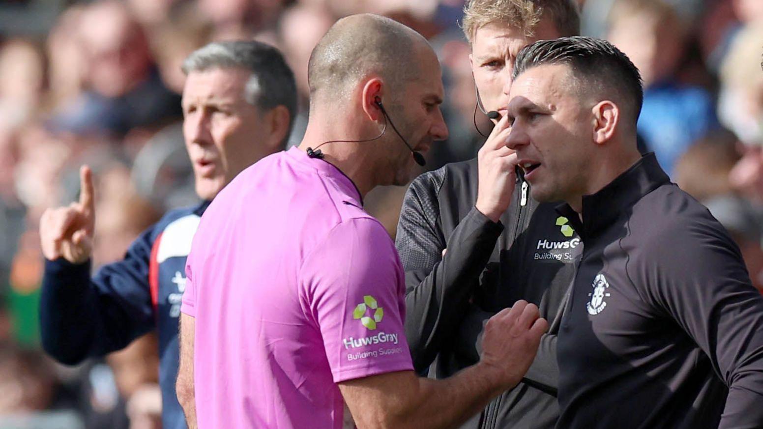 Referee Tim Robinson speaks to Matt Bloomfield during Luton's game with Doncaster