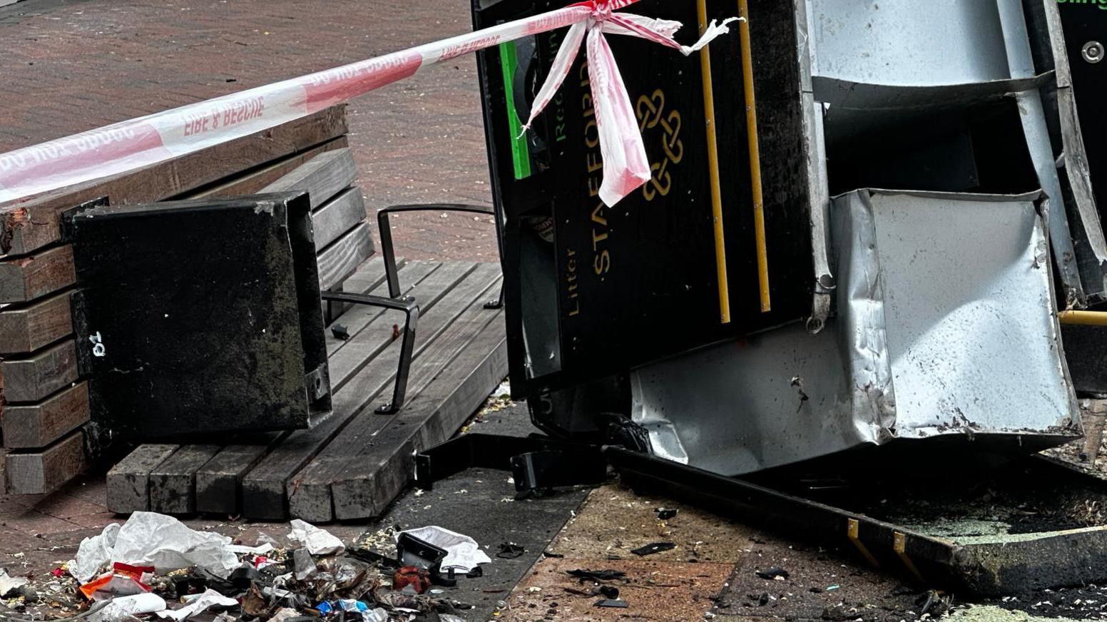 A damaged bin and bench