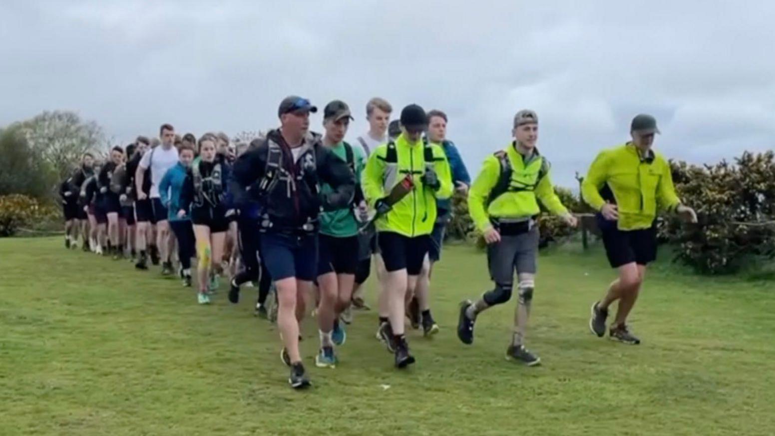 Students running on the coast path