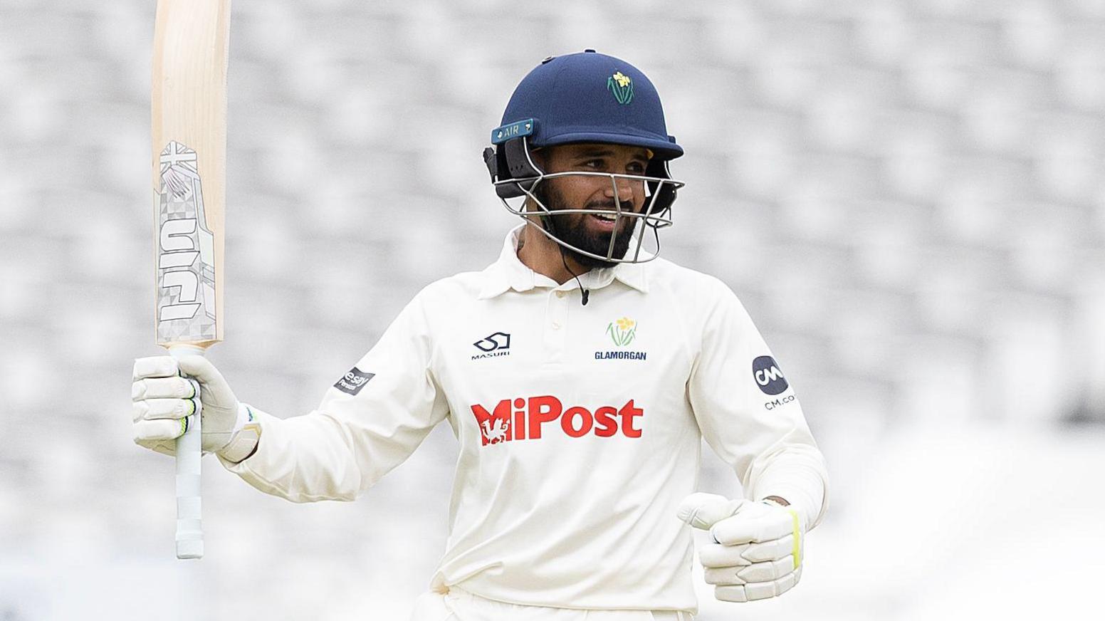 Zain ul Hassan raises his bat with his right hand to acknowledge scoring his hundred against Hampshire