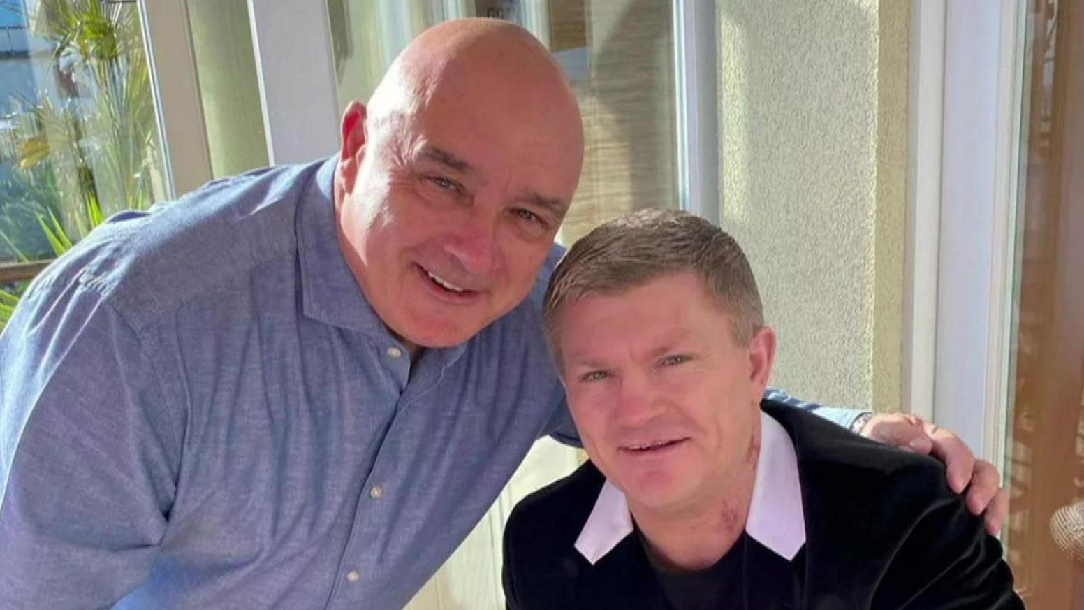 Paul Speak, a bald man, wears a blue open-collared shirt and has his left arm around Ricky Hatton's shoulder. Hatton is photographed wearing a black T-shirt and blazer with a white collar. They both smile as they pose for the camera together.