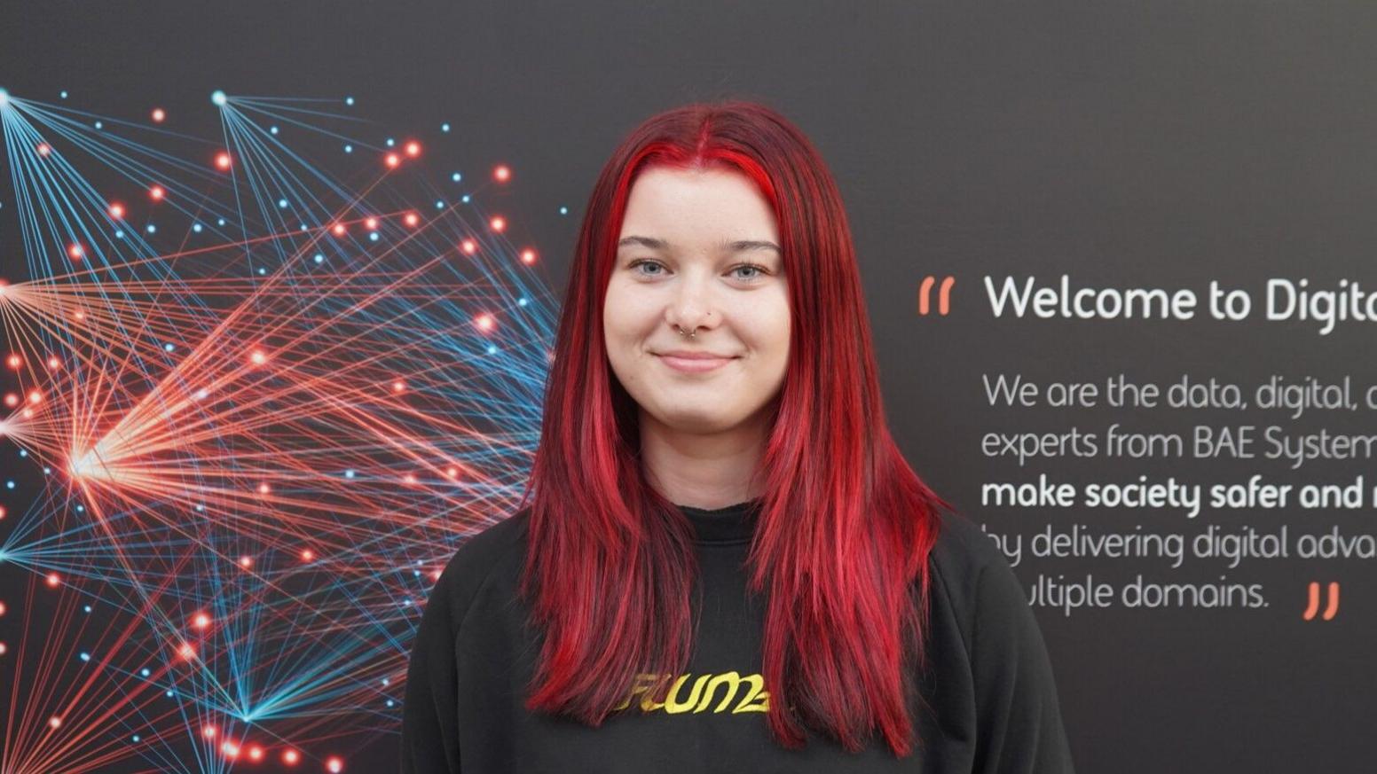 Alice Overend smiling with long dark red hair