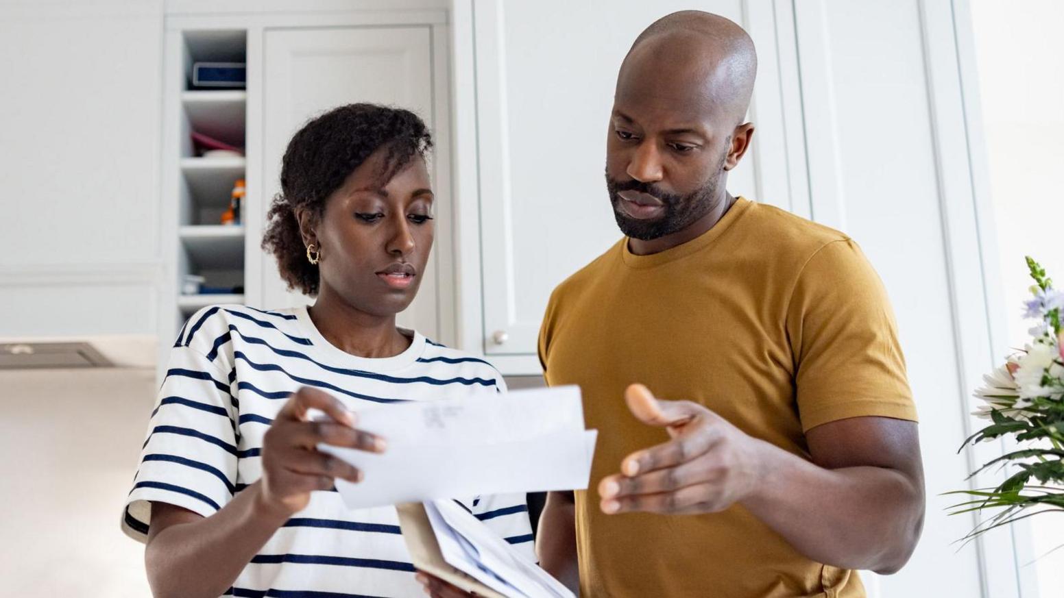 A worried couple looking at a bill 