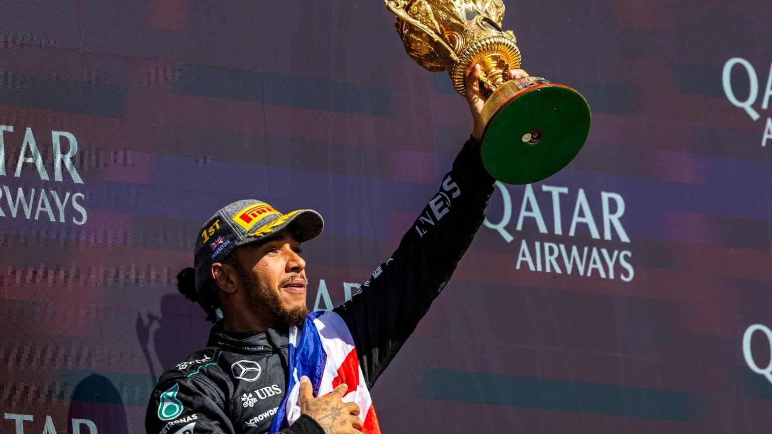 Lewis Hamilton lifts a race trophy