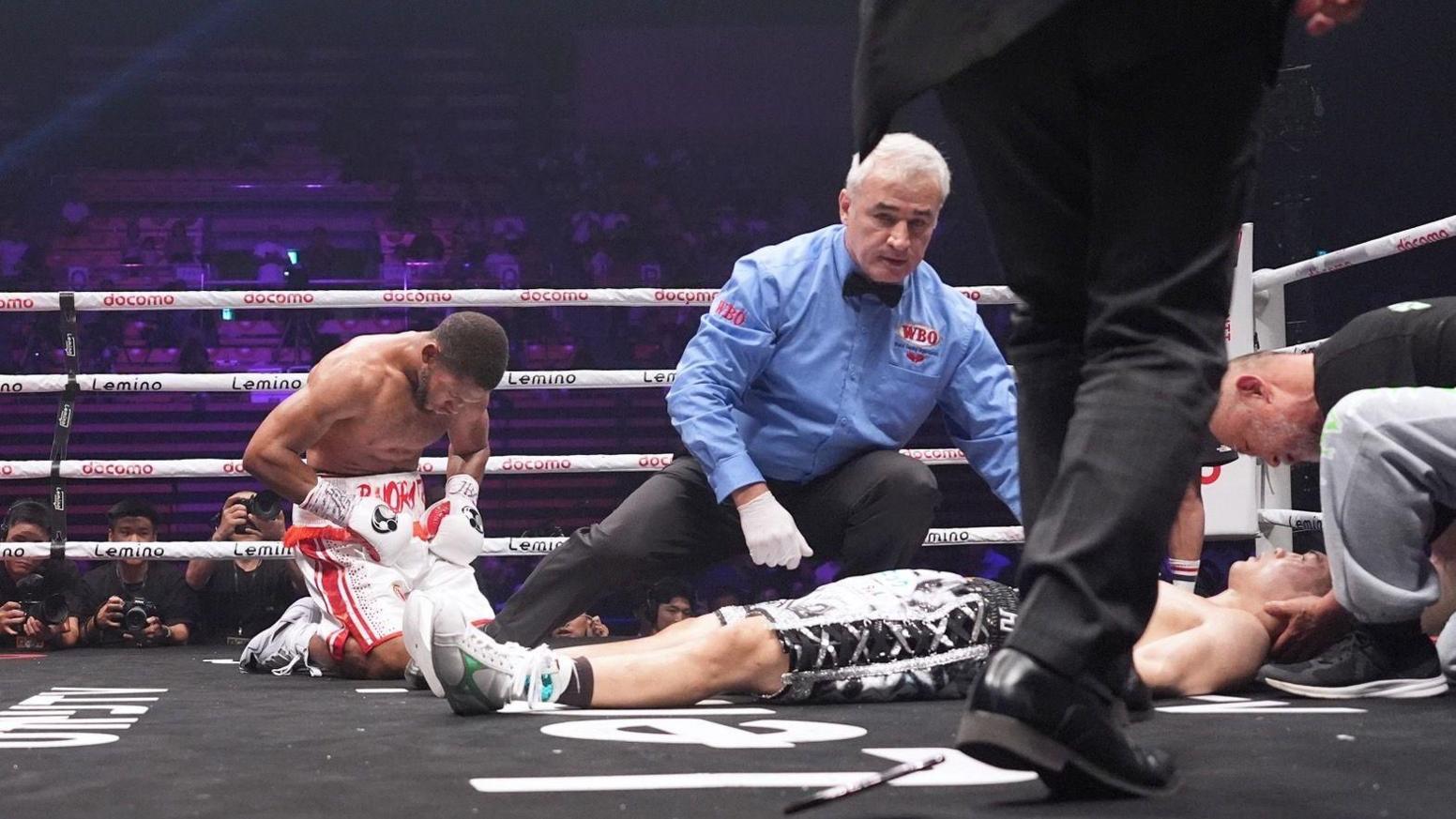 Brian Norman Jr bows as an unconscious Jin Sasaki is attended to by the referee and his team