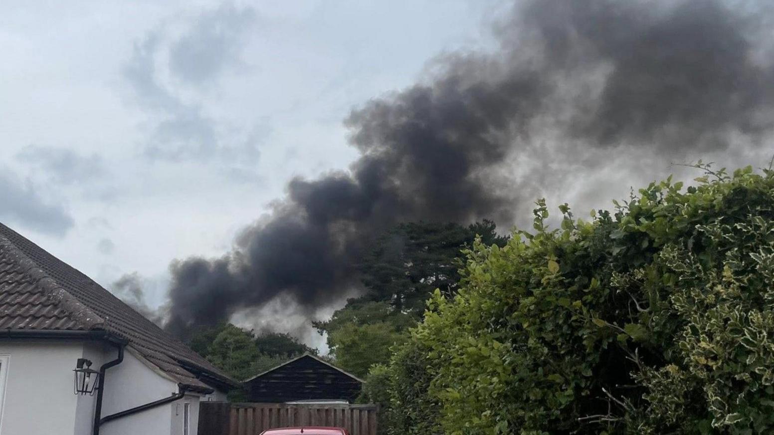 An image showing thick black plumes of smoke billowing into the sky