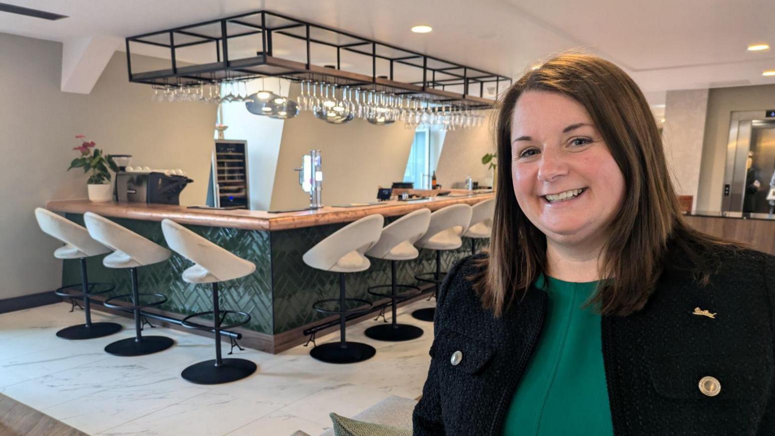 Woman with indoor bar area with seating in the background