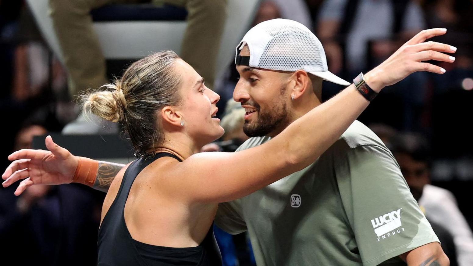 Aryna Sabalenka and Nick Kyrgios hug at the net