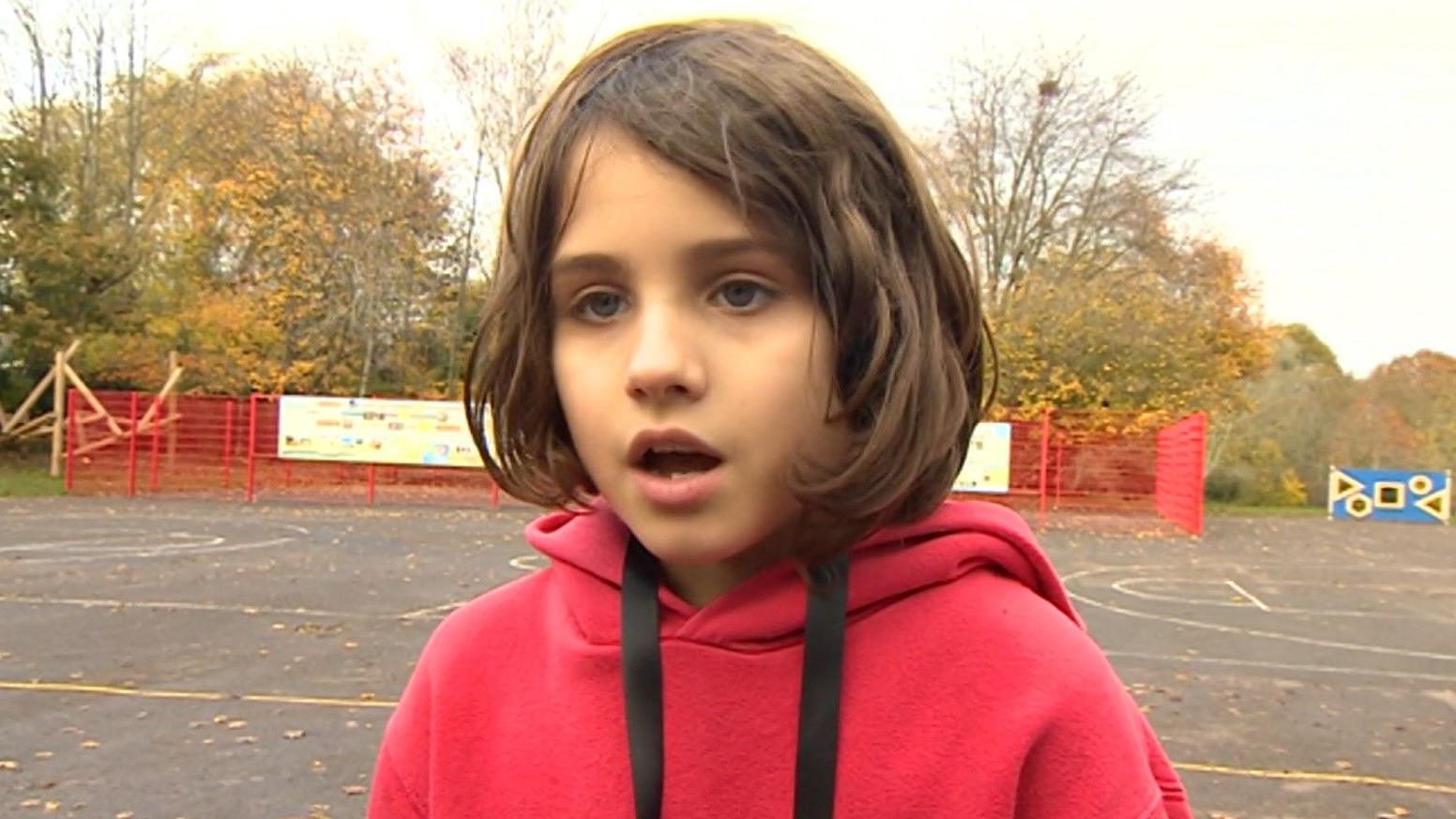 Playpod monitor Layla wearing a red school hoodie