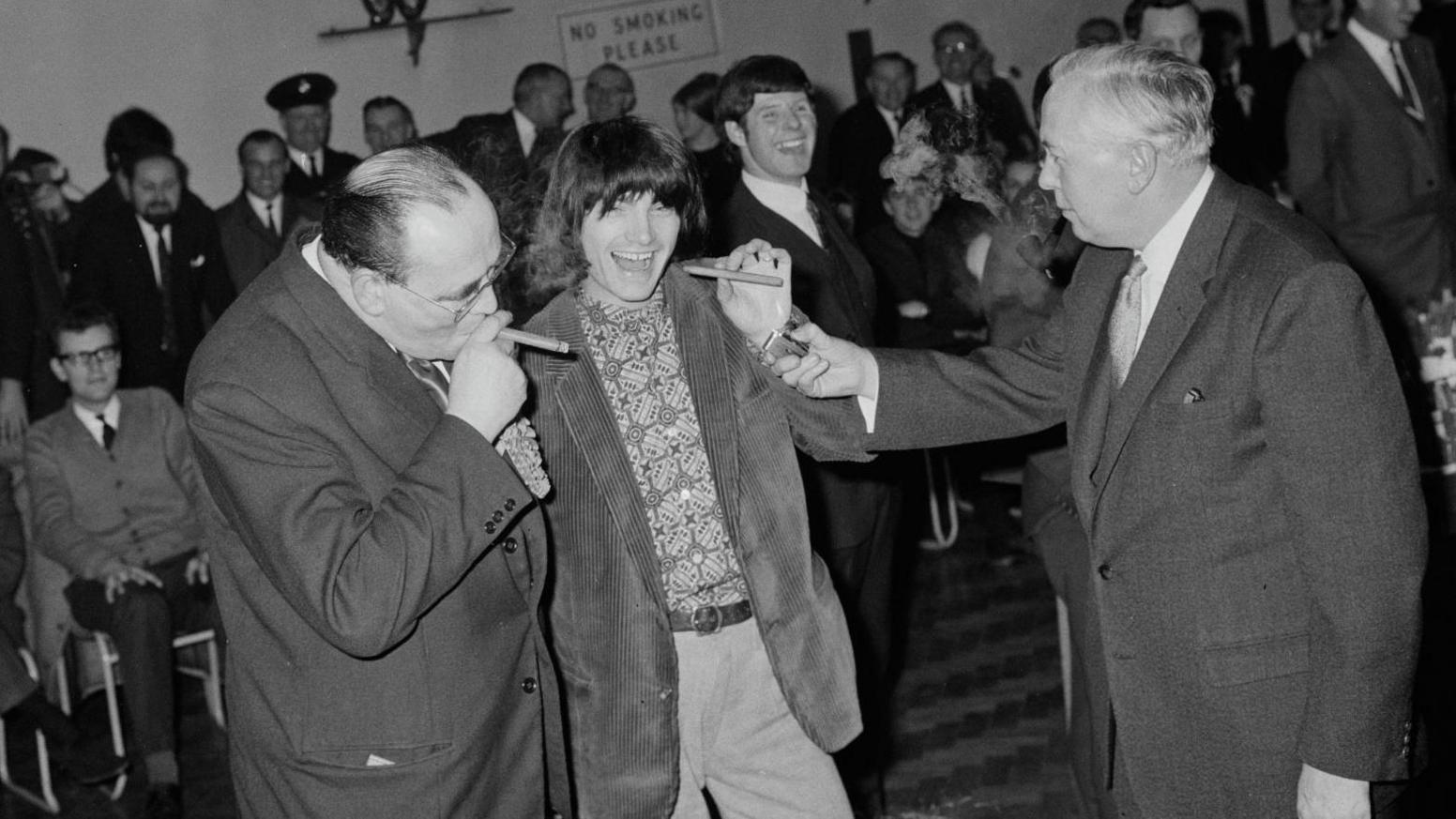 Conservative candidate Thomas Lyrian Hobday (l), David 'Screaming Lord Sutch' (c) and then-prime minister Harold Wilson (r) share cigars after the results of the Huyton election in 1966