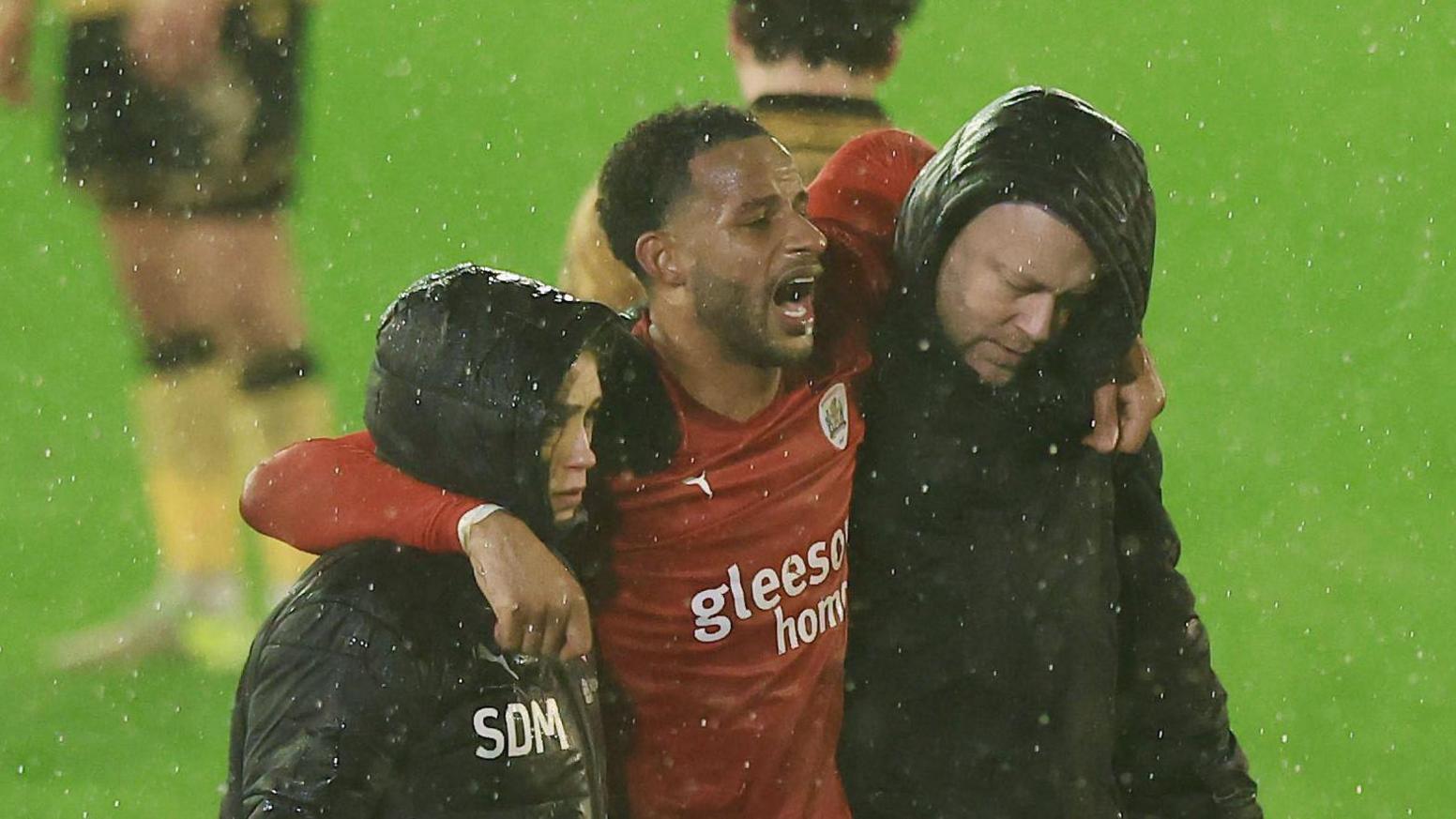 Barnsley's Barry Cotter is helped off the field