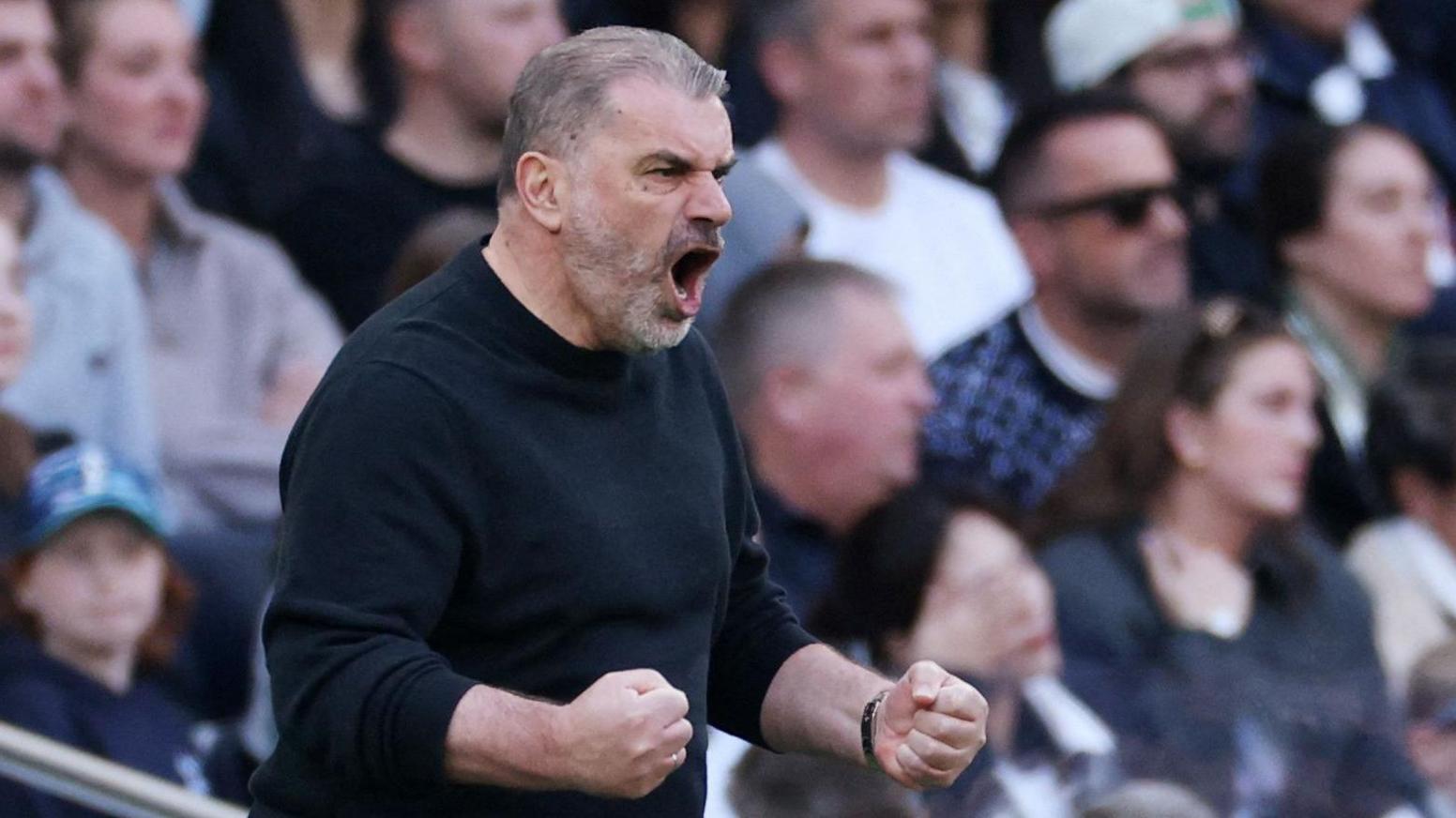 Ange Postecoglou holds up his fists and shouts as Tottenham play Bournemouth