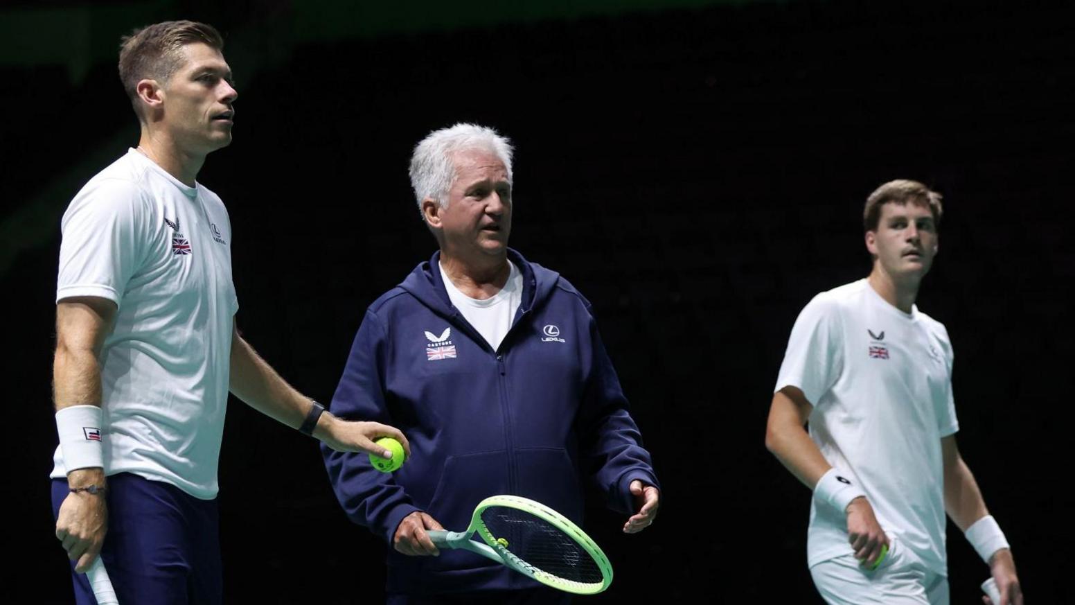 Louis Cayer gives advice to British doubles players Neal Skupski and Henry Patten at a Davis Cup tie in 2024