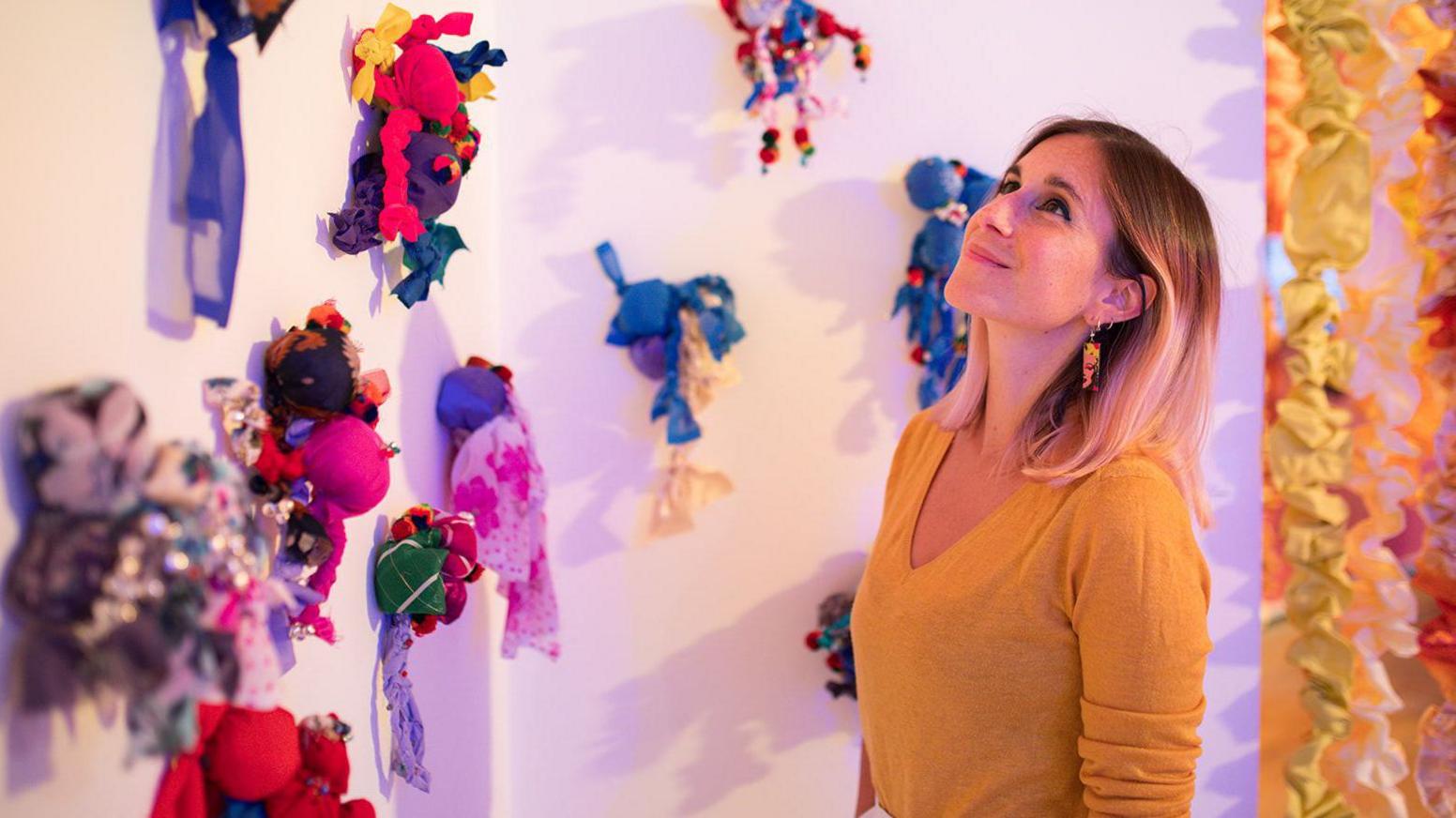 A woman looks up at some of the colourful displays in the gallery.