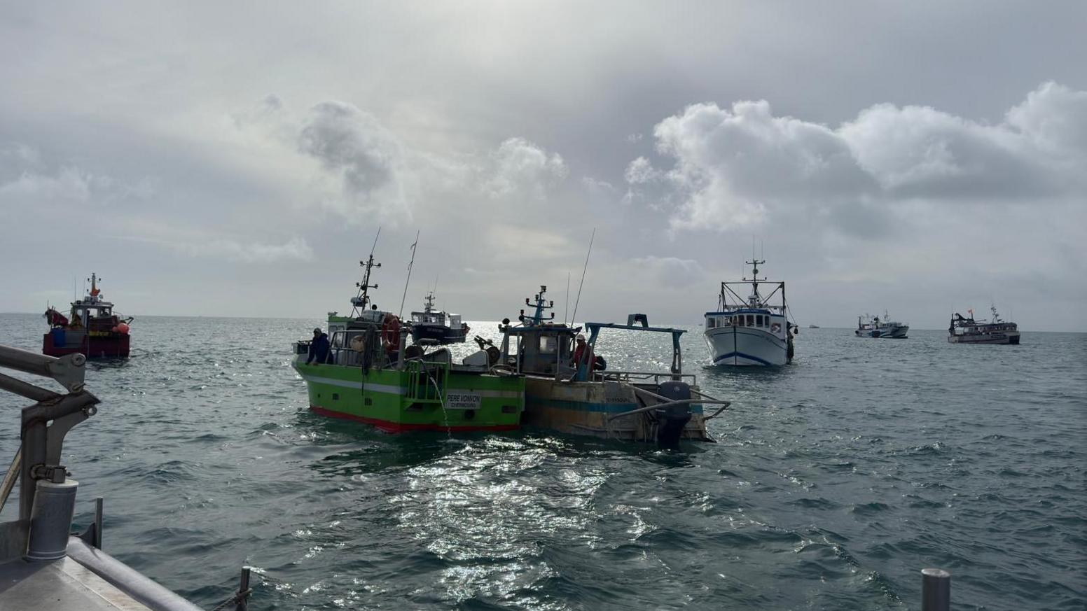 A number of fishing boats have gathered at the Minquiers as part of a staged protest. Five fishing boats can be seen on the calm waters.