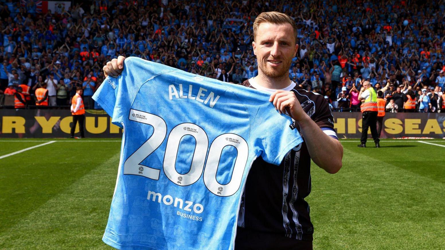 Jamie Allen holds up a special commemorative Coventry City shirt showing his surname and the number 200 underneath, marking his double century of appearances for the club.
